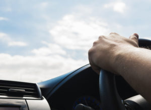 Man driving car using one hand